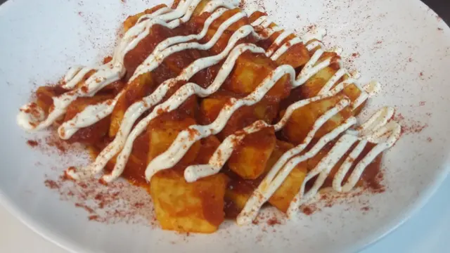 Patatas con salsa roja, alioli en hilo y pimentón